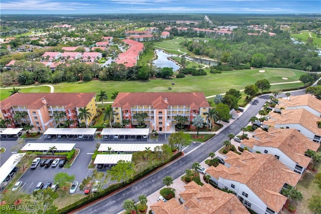 birds eye view of property with view of golf course and a water view