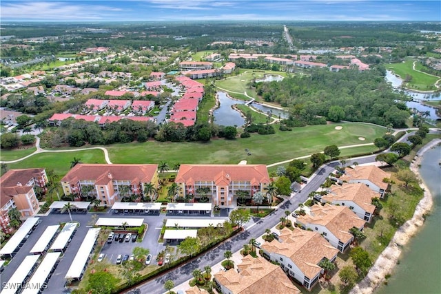 birds eye view of property with view of golf course and a water view