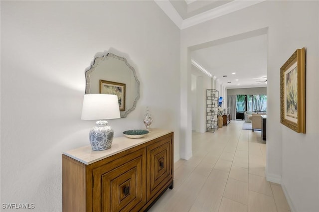 hallway with ornamental molding and baseboards