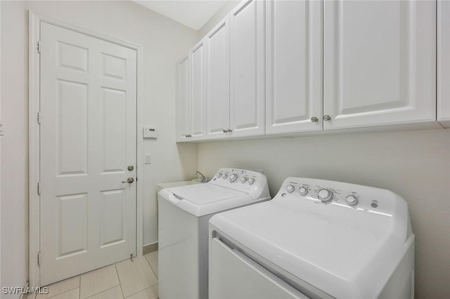 clothes washing area featuring cabinet space and washing machine and dryer