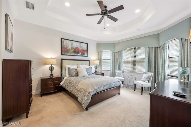 bedroom featuring crown molding, a raised ceiling, visible vents, and light colored carpet