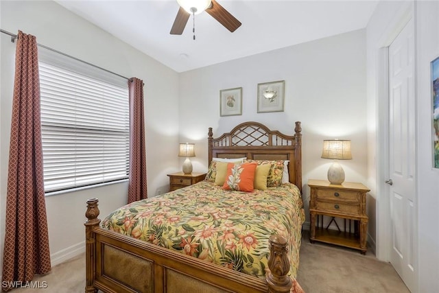 bedroom featuring ceiling fan, baseboards, and light colored carpet