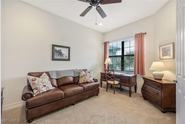 living room with baseboards, ceiling fan, and light colored carpet