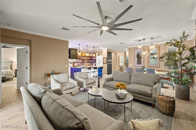 living room featuring ceiling fan with notable chandelier, light wood-type flooring, visible vents, and crown molding