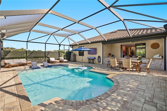 outdoor pool featuring glass enclosure, outdoor dining space, and a patio area