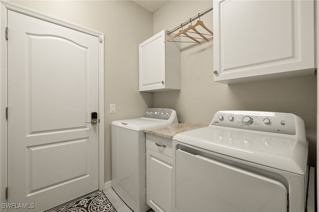 washroom featuring separate washer and dryer and cabinet space