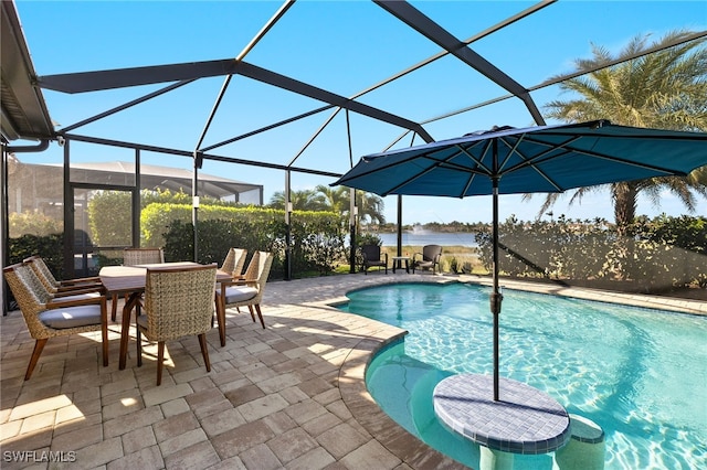 pool featuring glass enclosure, a patio, and a water view