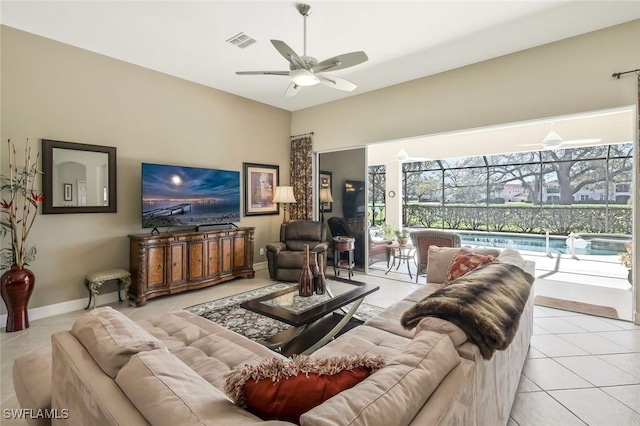 living room with light tile patterned floors, visible vents, a sunroom, ceiling fan, and baseboards