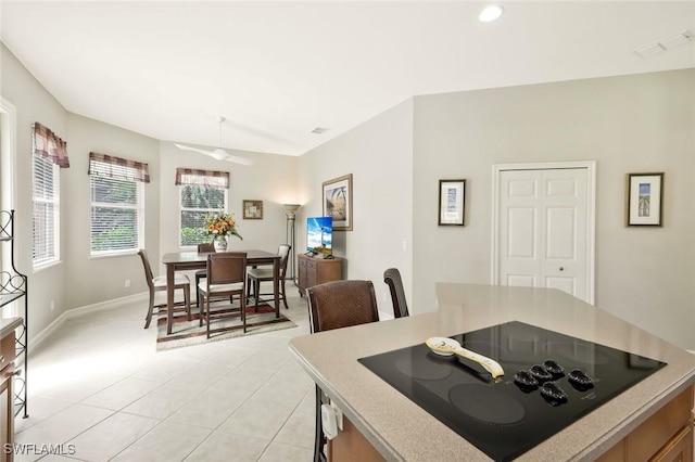 kitchen featuring light tile patterned floors, black electric stovetop, visible vents, baseboards, and light countertops