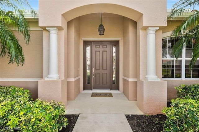 entrance to property featuring stucco siding