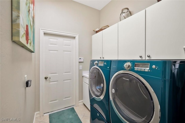 washroom featuring light tile patterned flooring, independent washer and dryer, and cabinet space