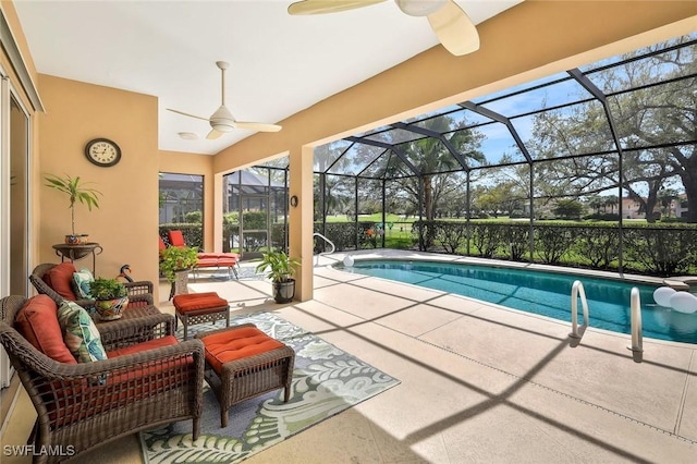 pool featuring a patio area, glass enclosure, and a ceiling fan