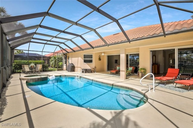 view of swimming pool featuring a patio area, a pool with connected hot tub, and glass enclosure