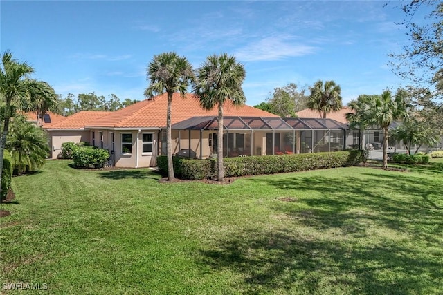 back of house with glass enclosure, a lawn, a tile roof, and stucco siding