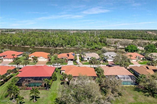 aerial view with a forest view, a water view, and a residential view