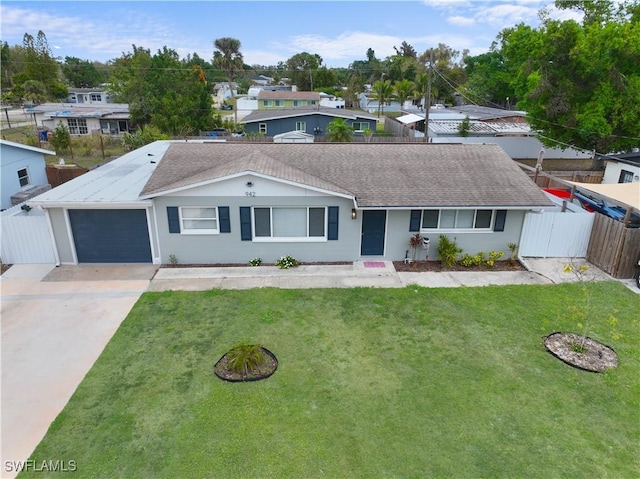 ranch-style house featuring a garage, concrete driveway, fence, and a front lawn