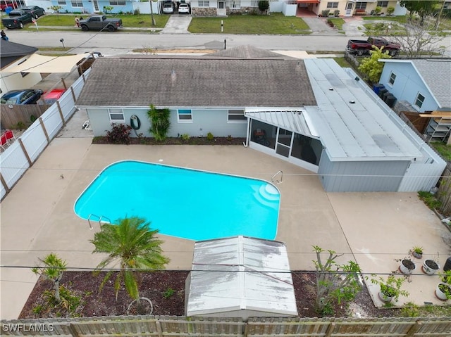 view of pool featuring a sunroom, a patio area, a fenced backyard, and a fenced in pool