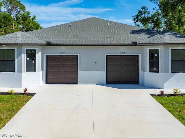 ranch-style home featuring an attached garage, stucco siding, concrete driveway, and roof with shingles