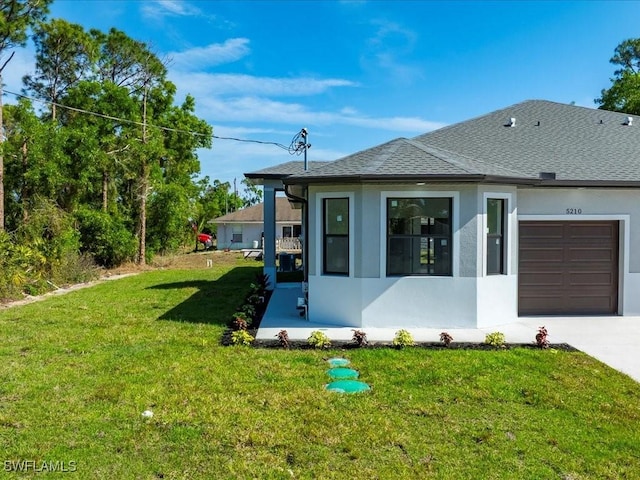 view of front of home featuring roof with shingles, stucco siding, concrete driveway, an attached garage, and a front yard