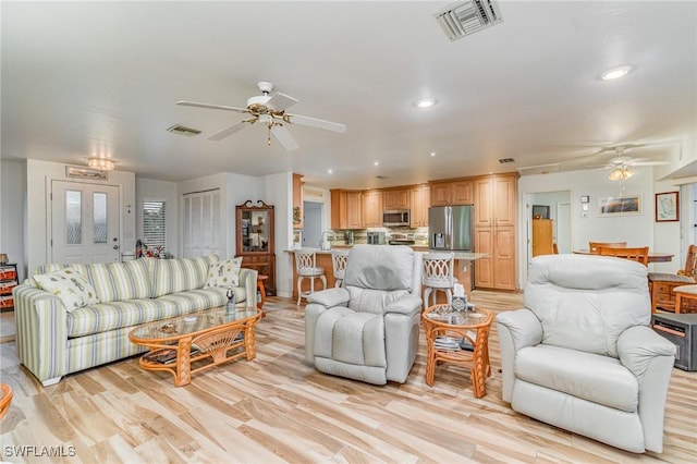 living area featuring ceiling fan, recessed lighting, visible vents, and light wood-style floors