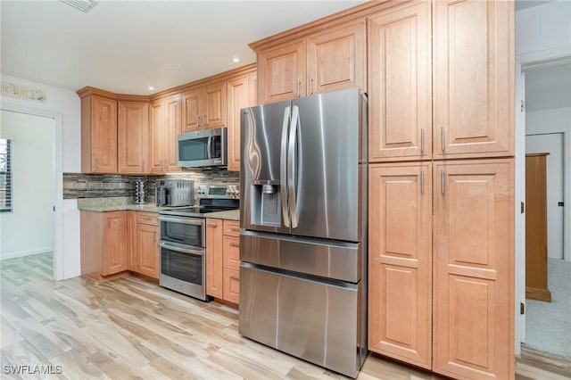 kitchen with light wood finished floors, recessed lighting, decorative backsplash, light brown cabinetry, and appliances with stainless steel finishes