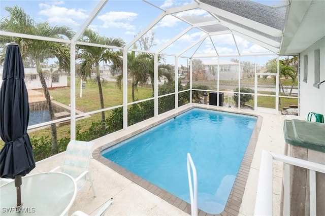 outdoor pool featuring a lawn, a patio area, and a lanai