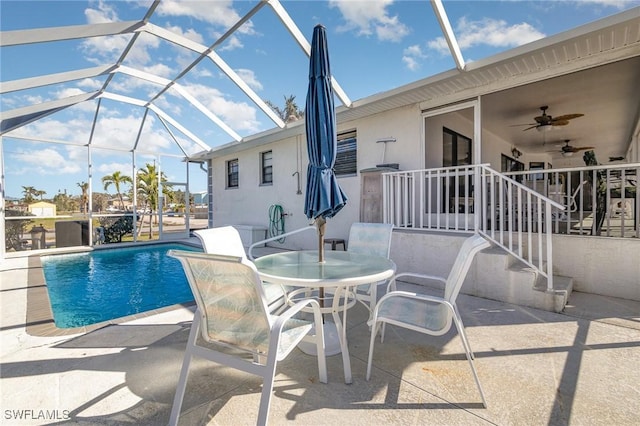 outdoor pool with outdoor dining space, a patio area, a lanai, and a ceiling fan