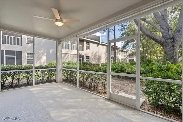 unfurnished sunroom featuring a ceiling fan