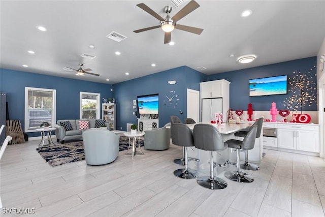 dining space with light wood-type flooring, visible vents, ceiling fan, and recessed lighting