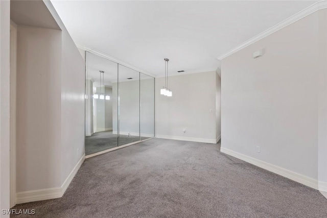 spare room with crown molding, baseboards, and carpet flooring