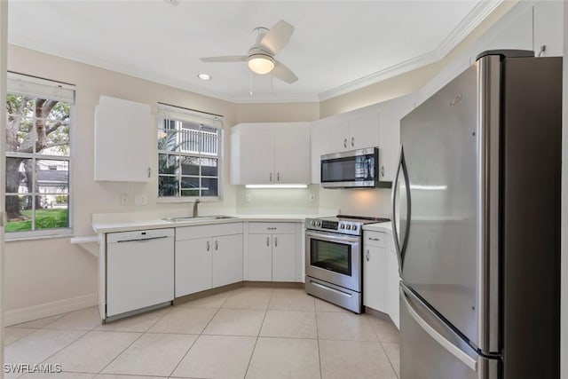 kitchen with stainless steel appliances, white cabinets, light countertops, and a sink