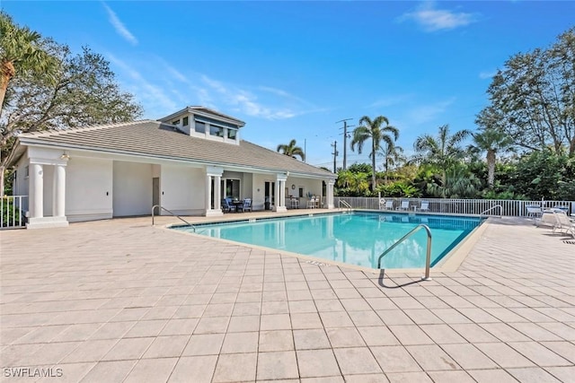 community pool with fence and a patio