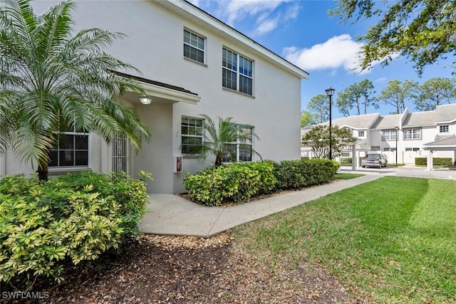 view of home's exterior featuring a yard and stucco siding