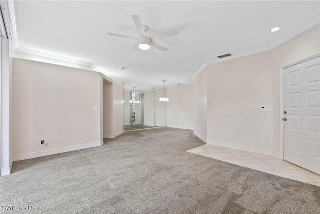 unfurnished room featuring baseboards, visible vents, a ceiling fan, ornamental molding, and carpet floors