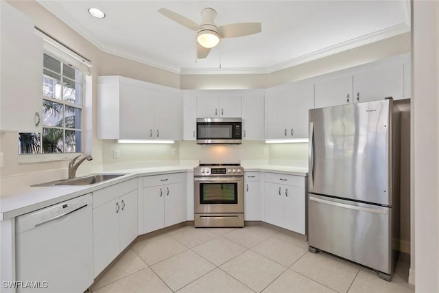 kitchen with stainless steel appliances, light countertops, crown molding, and a sink