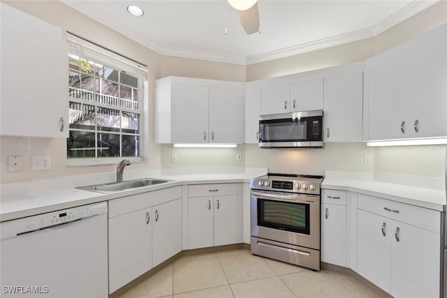 kitchen with light countertops, appliances with stainless steel finishes, a sink, and crown molding