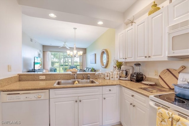 kitchen featuring white appliances, a notable chandelier, a sink, and white cabinets