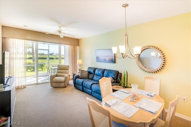 carpeted dining space featuring baseboards and ceiling fan with notable chandelier