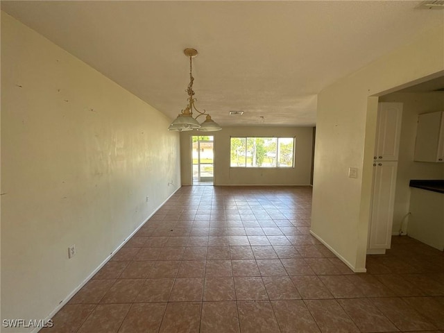 tiled empty room with baseboards and visible vents