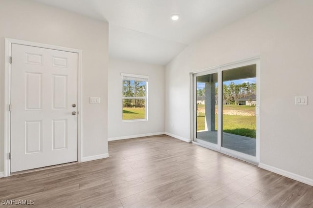 interior space with lofted ceiling, light wood-style floors, and baseboards