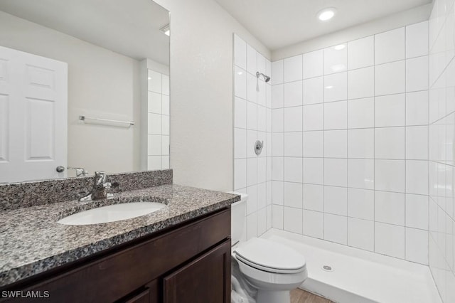 full bath with toilet, a tile shower, and vanity