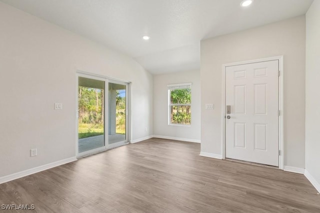 interior space with lofted ceiling, recessed lighting, baseboards, and wood finished floors