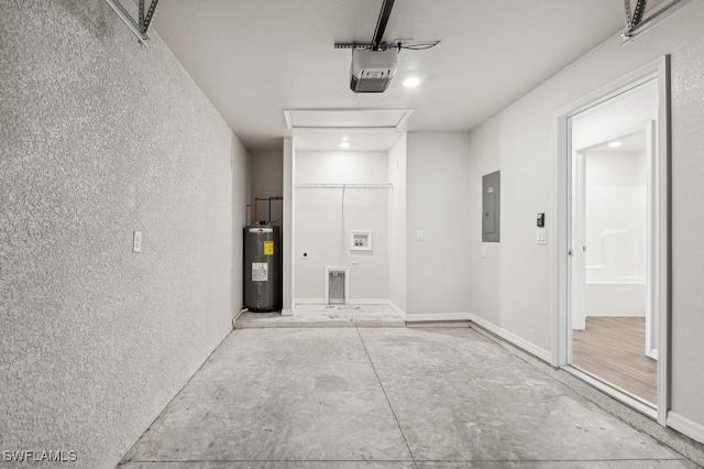 garage featuring a garage door opener, a textured wall, electric water heater, electric panel, and baseboards