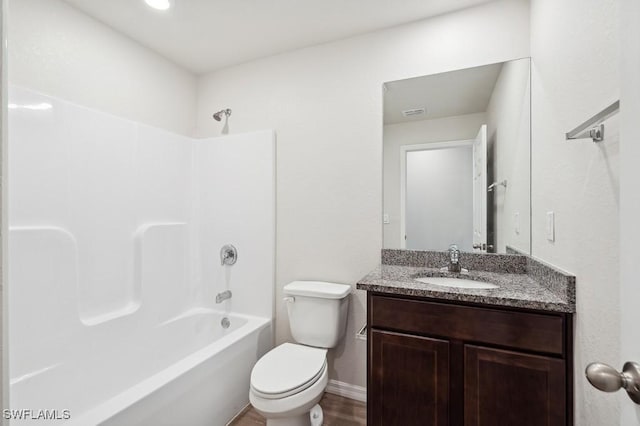 full bath with toilet, washtub / shower combination, vanity, wood finished floors, and baseboards