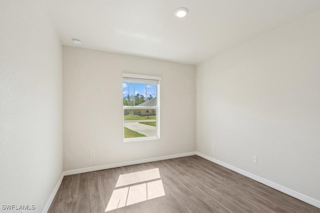 empty room featuring light wood finished floors and baseboards