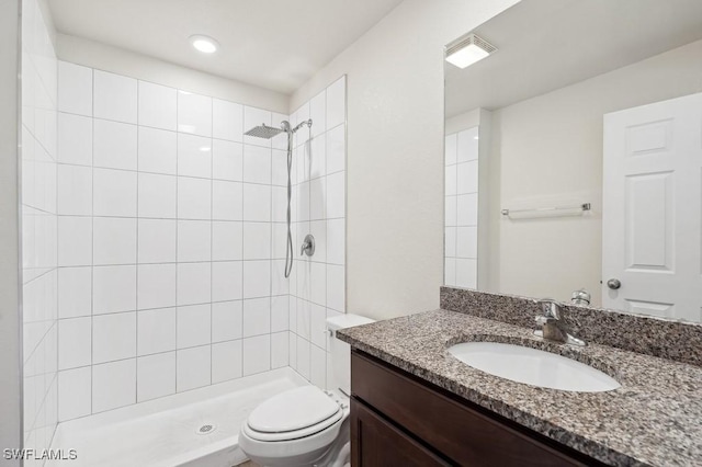 full bath with visible vents, vanity, toilet, and tiled shower