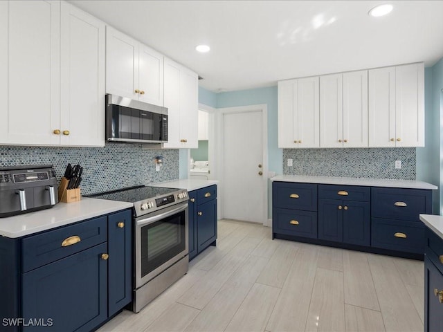 kitchen featuring stainless steel appliances, light countertops, backsplash, white cabinets, and blue cabinets