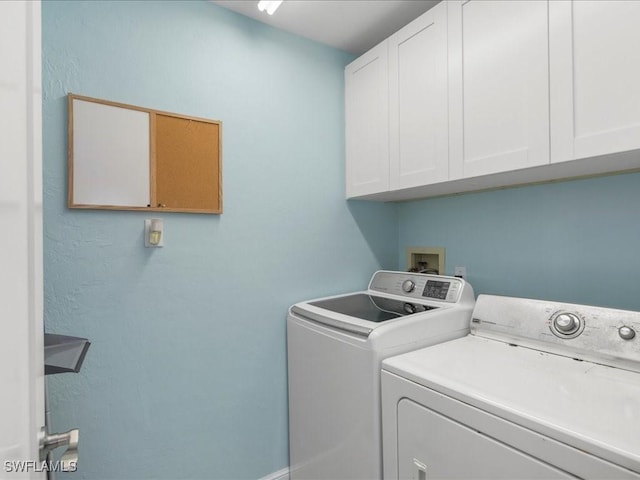 clothes washing area with cabinet space and independent washer and dryer