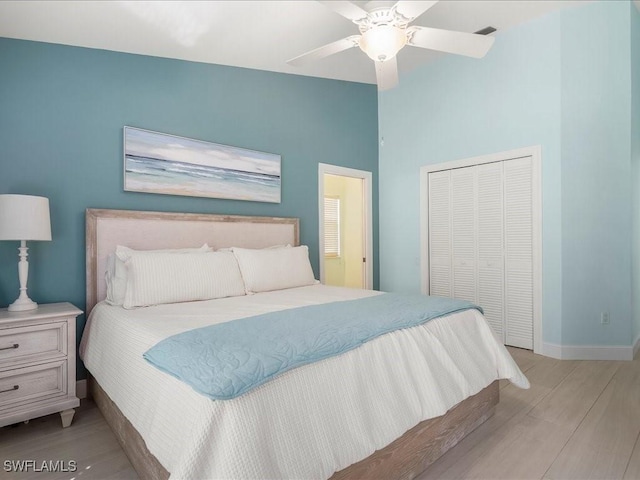 bedroom featuring lofted ceiling, a closet, visible vents, light wood-type flooring, and baseboards