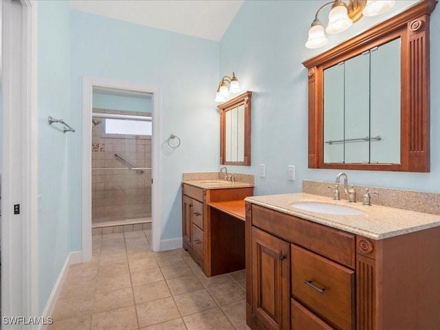 full bath with two vanities, a sink, a tile shower, and tile patterned floors